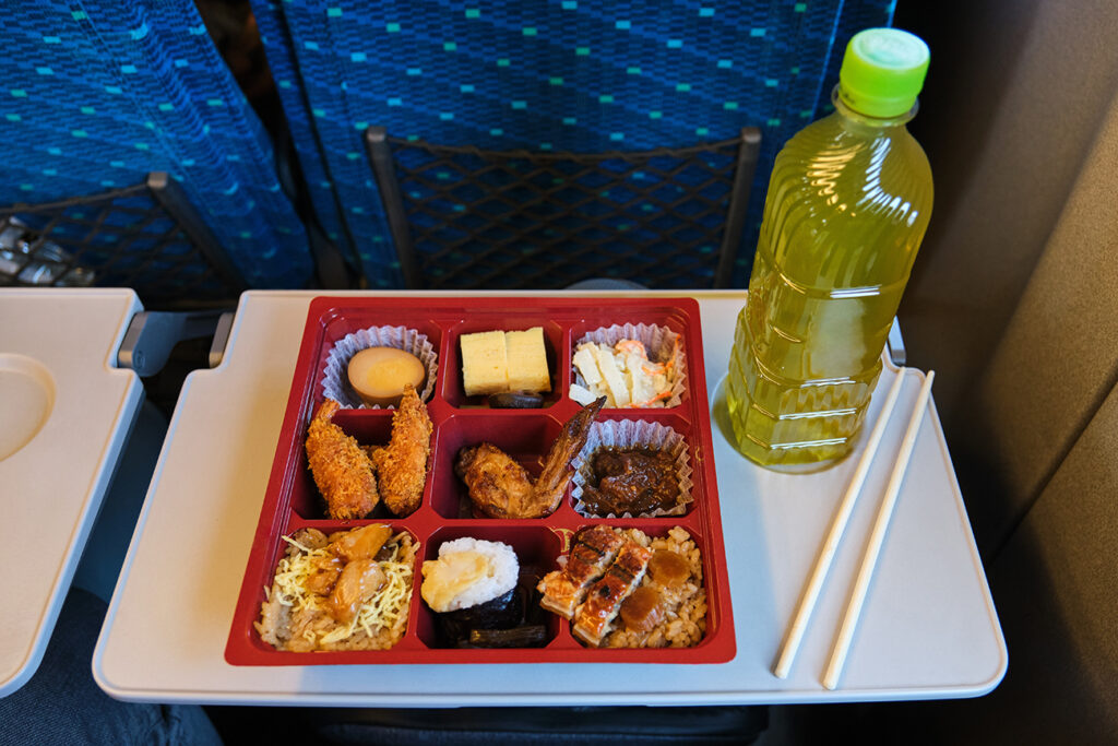 Japanese Eki Bento, lunch box, and a bottle of green tea on a Shinkansen Train in Japan.